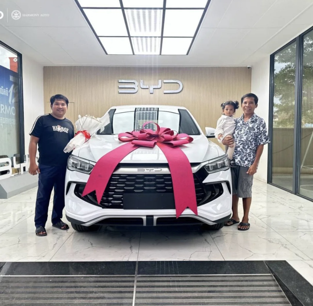 Customer and family in front of BYD with bow